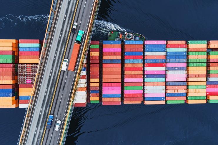 large shipping boat going under a bridge