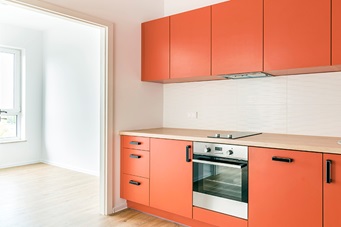 sleek modern kitchen with orange cabinets and cupboards