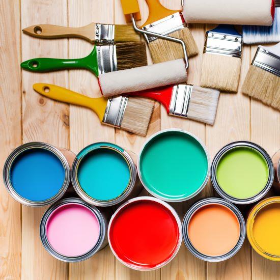 paint brushes and paint cans on a wood surface