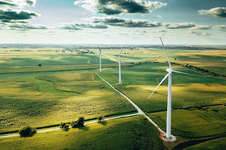 Windmills near a series of green fields
