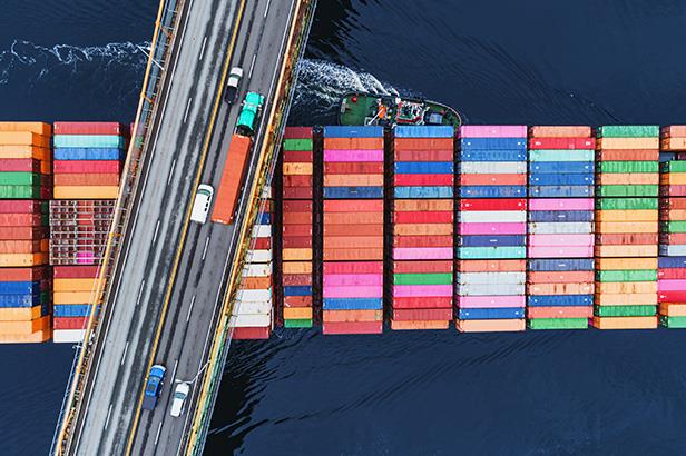 Shipping container travelling under a bridge