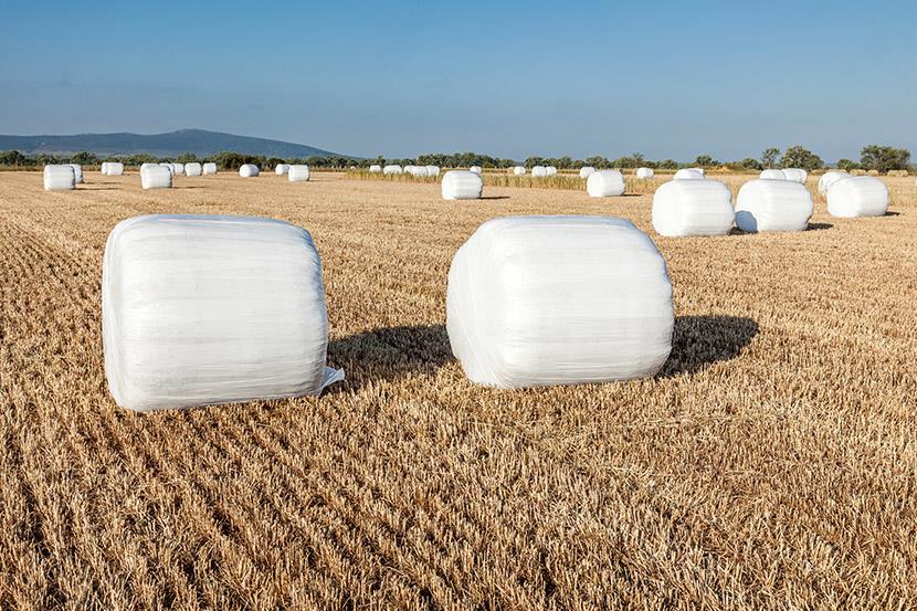 hay bales covered in white plastic wrap sitting in a field