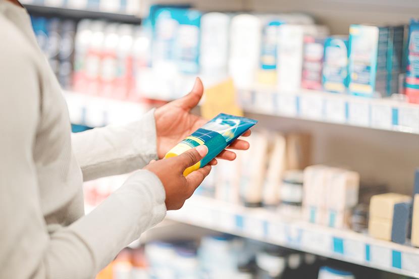 person looking at different products in a store aisle