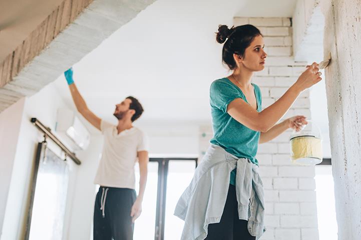 man and woman painting a room in a house
